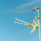 Antena telewizji naziemnej na tle błękitnego nieba. Dowiedz się, jak odbierać tv naziemna.