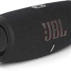 Czarny głośnik JBL z czerwonym logo. Dowiedz się, jak podłączyć słuchawki JBL do telefonu, by cieszyć się muzyką.
