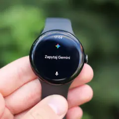 Zegarek z Wear OS na ręce, wyświetla godzinę 17:08 i komunikat "Zapytaj Gemini".