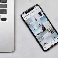 Telefon z Instagramem obok klawiatury laptopa. Dowiedz się, jak połączyć telefon z komputerem przez wifi, by łatwo przesyłać zdjęcia.