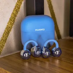 Niebieskie etui Huawei i błyszczące słuchawki bezprzewodowe. Dowiedz się, jak sparować słuchawki bezprzewodowe Huawei z telefonem.