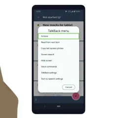 Palec wskazuje menu TalkBack, gdzie widać opcję "Akcje".
