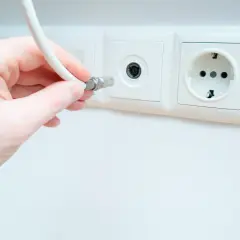 Dłoń podłącza kabel do gniazdka antenowego. Pytanie: jaki kabel do anteny naziemnej?