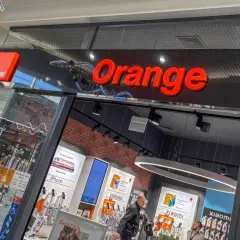Salon Orange z ofertą "konto ważne rok". W witrynie widać telefony iPhone, Samsung, Xiaomi i ofertę światłowodu.