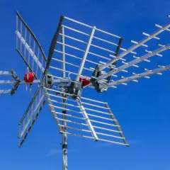 Antena telewizyjna na tle błękitnego nieba. Dowiedz się, jak poprawić sygnał anteny TV, by cieszyć się lepszym obrazem.