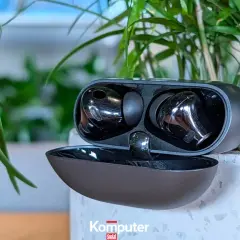 Czarne słuchawki Huawei w etui, otoczone zielenią. Zastanawiasz się, dlaczego słuchawki Huawei nie chcą się połączyć? Sprawdź, czy są naładowane i sparowane.