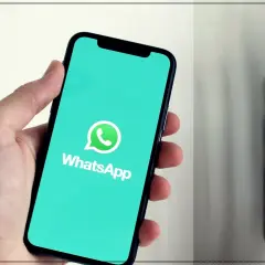 Dłoń trzyma smartfon z logo WhatsApp. Dowiedz się, jak dzwonić bez karty SIM, korzystając z tej popularnej aplikacji.