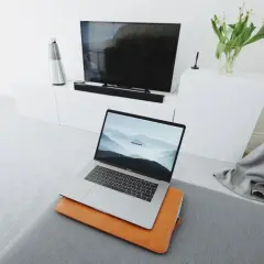 Nowoczesny salon z laptopem przygotowanym do screen mirroring na dużym ekranie telewizora.