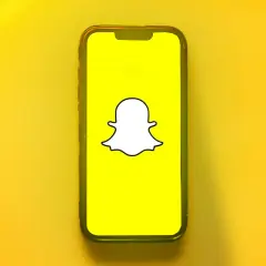 Telefon z logo Snapchata. Dowiedz się, jak odzyskać dni na Snapie, gdy przypadkowo je stracisz.