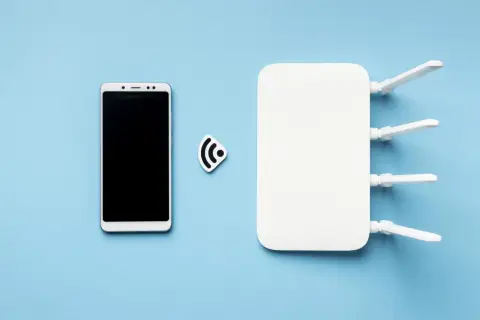 Biały smartfon i router Wi-Fi z antenkami, symbolizujące tethering.