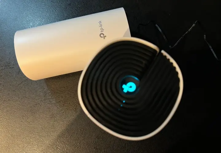Dwa urządzenia TP-Link, jedno białe, drugie czarne z niebieskim logo. Chcesz wiedzieć, jak zmienić hasło do wifi?