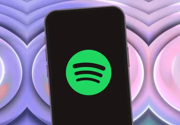 Telefon z logo Spotify, zapowiadający jakość dźwięku spotify hifi. Tło w odcieniach fioletu i różu.