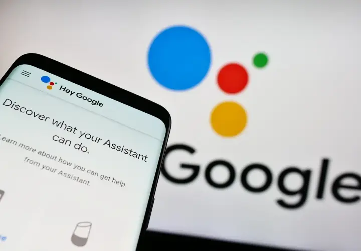 Telefon z ekranem "Hey Google" i logo Asystenta. Dowiedz się, jak wyłączyć Asystenta Google, jeśli potrzebujesz.