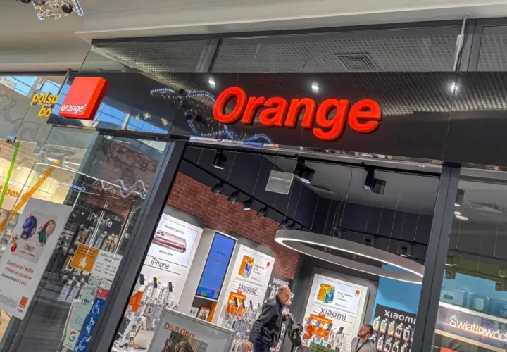 Salon Orange z ofertą "konto ważne rok". W witrynie widać telefony iPhone, Samsung, Xiaomi i ofertę światłowodu.