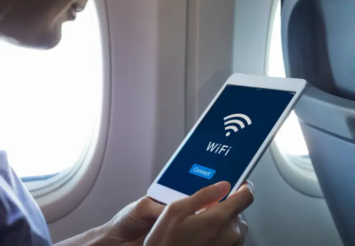 Osoba w samolocie sprawdza na tablecie, czy w samolocie Ryanair jest wifi. Widoczny przycisk "Connect".