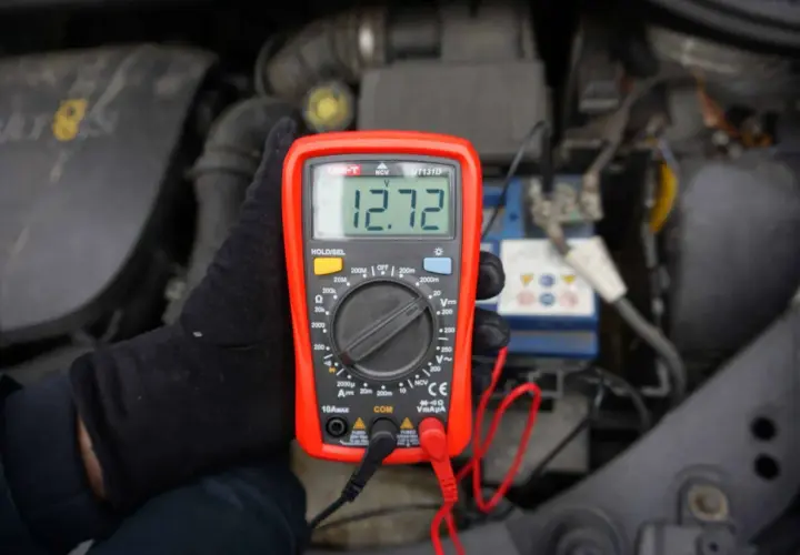 Sprawdzanie akumulatora miernikiem. Wynik 12.72V pokazuje, że jest w dobrym stanie.