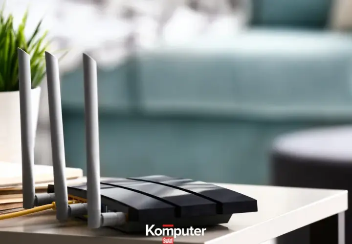Jak podłączyć dysk do routera? Czarny router z antenkami i żółtym kablem na stoliku, obok doniczka z zieloną rośliną.