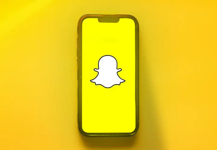 Telefon z logo Snapchata. Dowiedz się, jak odzyskać dni na Snapie, gdy przypadkowo je stracisz.