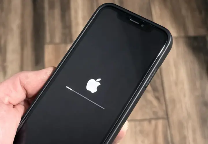 iPhone z logo Apple i paskiem postępu, aktualizacja iOS 26.3 w toku.