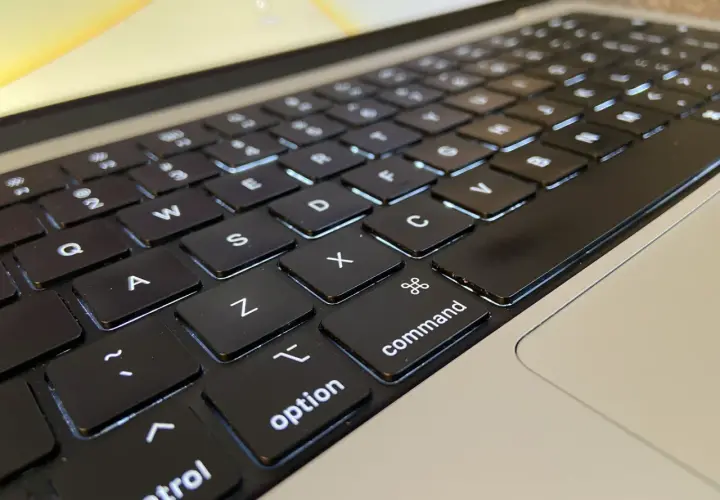 Klawiatura laptopa z podświetlanymi klawiszami. Widoczne litery Q, W, E, A, S, D, Z, X, C, a także klawisze "control", "option" i "command".