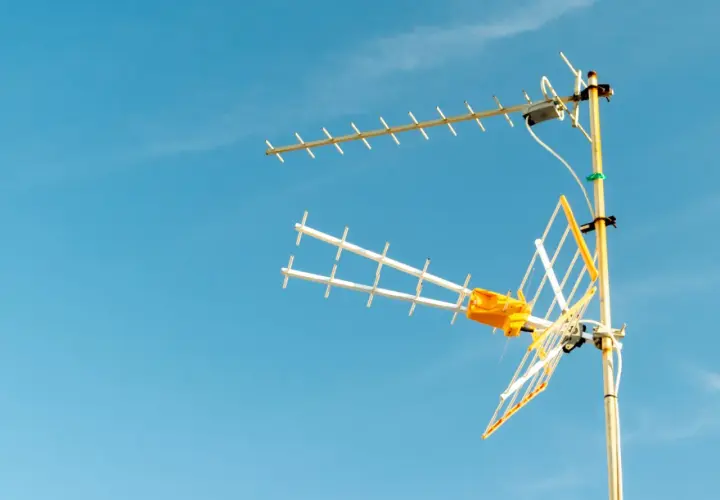 Antena telewizji naziemnej na tle błękitnego nieba. Dowiedz się, jak odbierać tv naziemna.