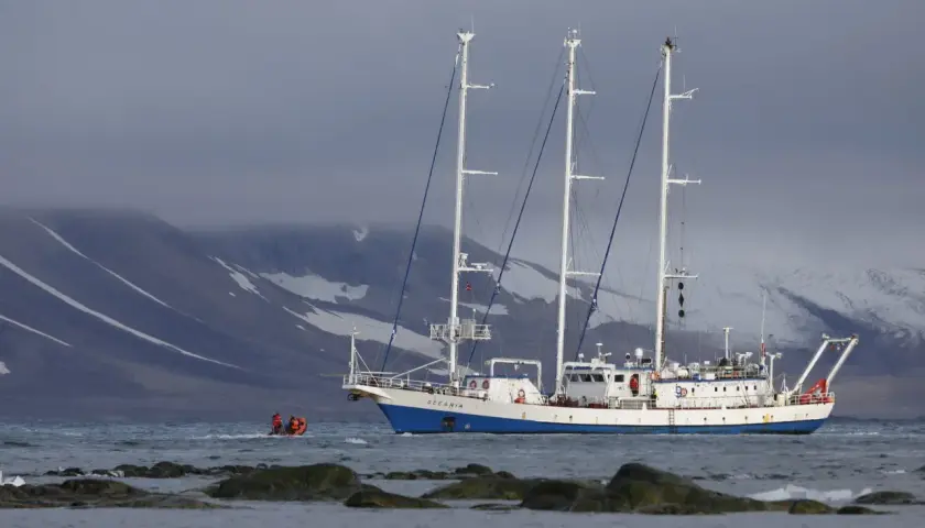 Statek badawczy "Oceania" na tle ośnieżonych gór. Mała łódź z ludźmi zbliża się do niego. Ciekawe, czy na morzu jest zasięg.