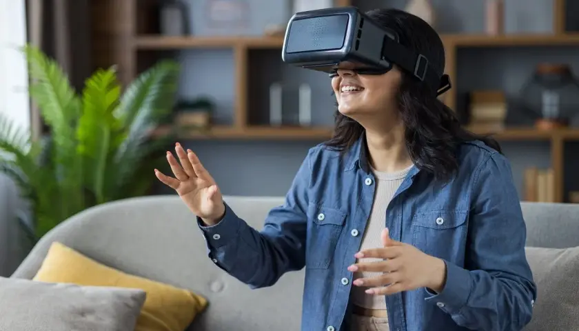 Kobieta w okularach VR, odkrywa jak zbudowane są okulary VR, zanurzając się w wirtualnym świecie.