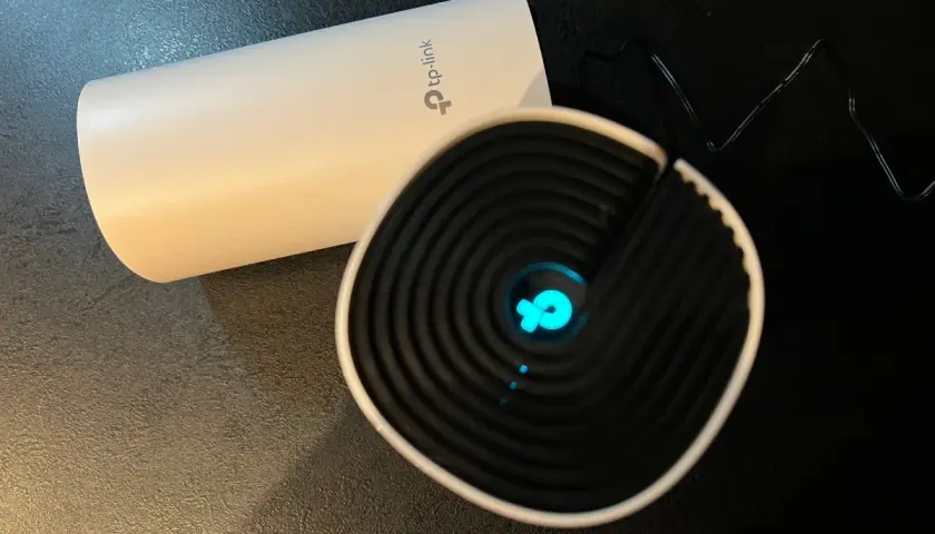 Dwa urządzenia TP-Link, jedno białe, drugie czarne z niebieskim logo. Chcesz wiedzieć, jak zmienić hasło do wifi?