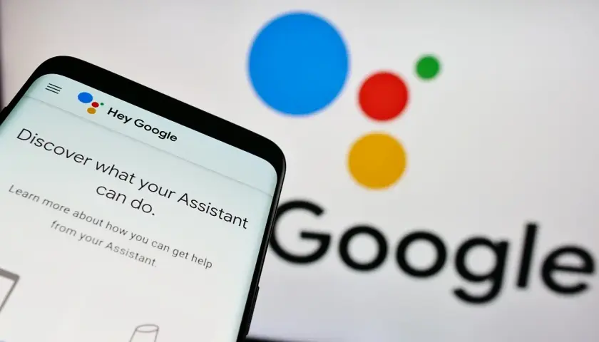 Telefon z ekranem "Hey Google" i logo Asystenta. Dowiedz się, jak wyłączyć Asystenta Google, jeśli potrzebujesz.