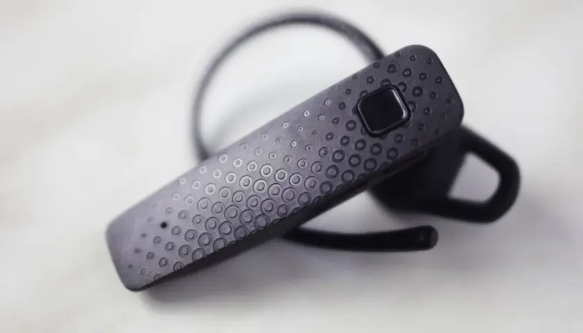 Czarna słuchawka Bluetooth z wzorem kółek. Dowiedz się, jak połączyć słuchawki Samsung z telefonem.