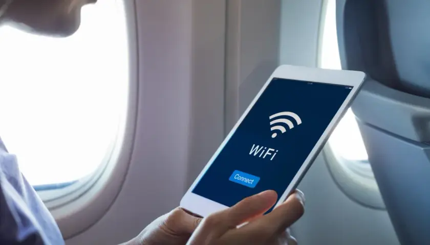 Osoba w samolocie sprawdza na tablecie, czy w samolocie Ryanair jest wifi. Widoczny przycisk "Connect".