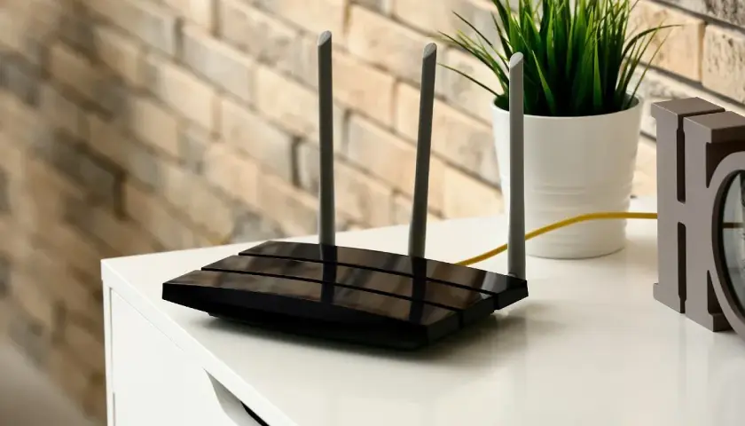 Router z antenkami, który zapewnia dostęp do sieci. Tak się pisze wi-fi, by mieć szybki internet w domu.