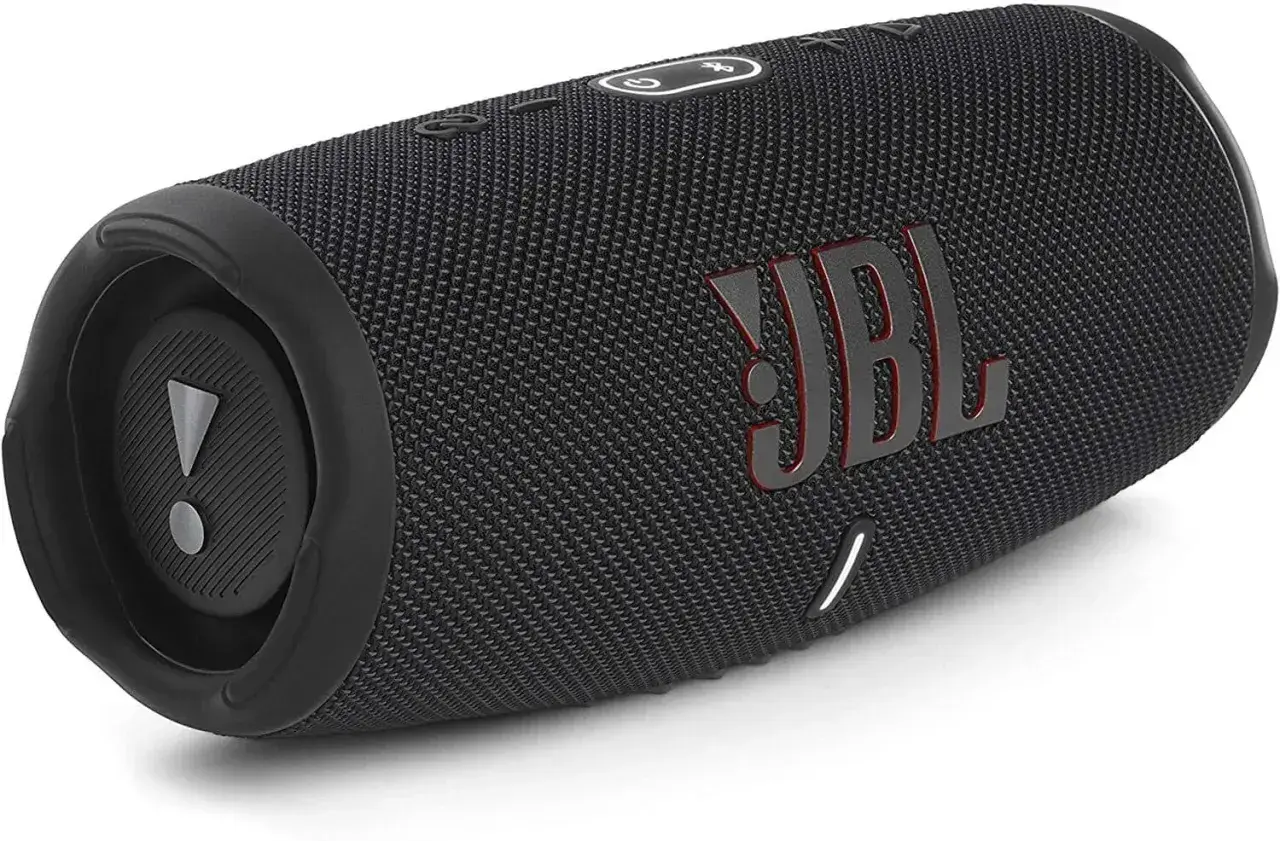 Czarny głośnik JBL z czerwonym logo. Dowiedz się, jak podłączyć słuchawki JBL do telefonu, by cieszyć się muzyką.
