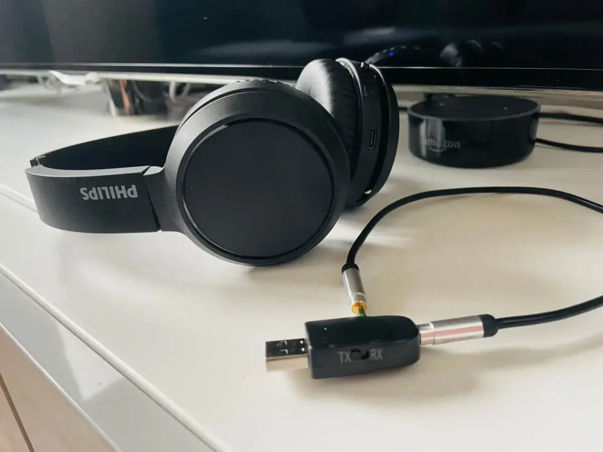 Czarne słuchawki Philips z adapterem USB-jack, pokazujące, jak podłączyć słuchawki do telefonu Samsung.