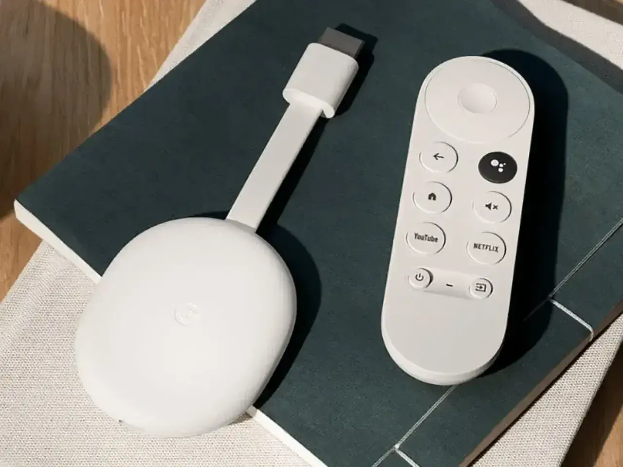 Biały Chromecast z pilotem, gotowy do podłączenia do telewizora. Ułatwia strumieniowanie ulubionych treści.