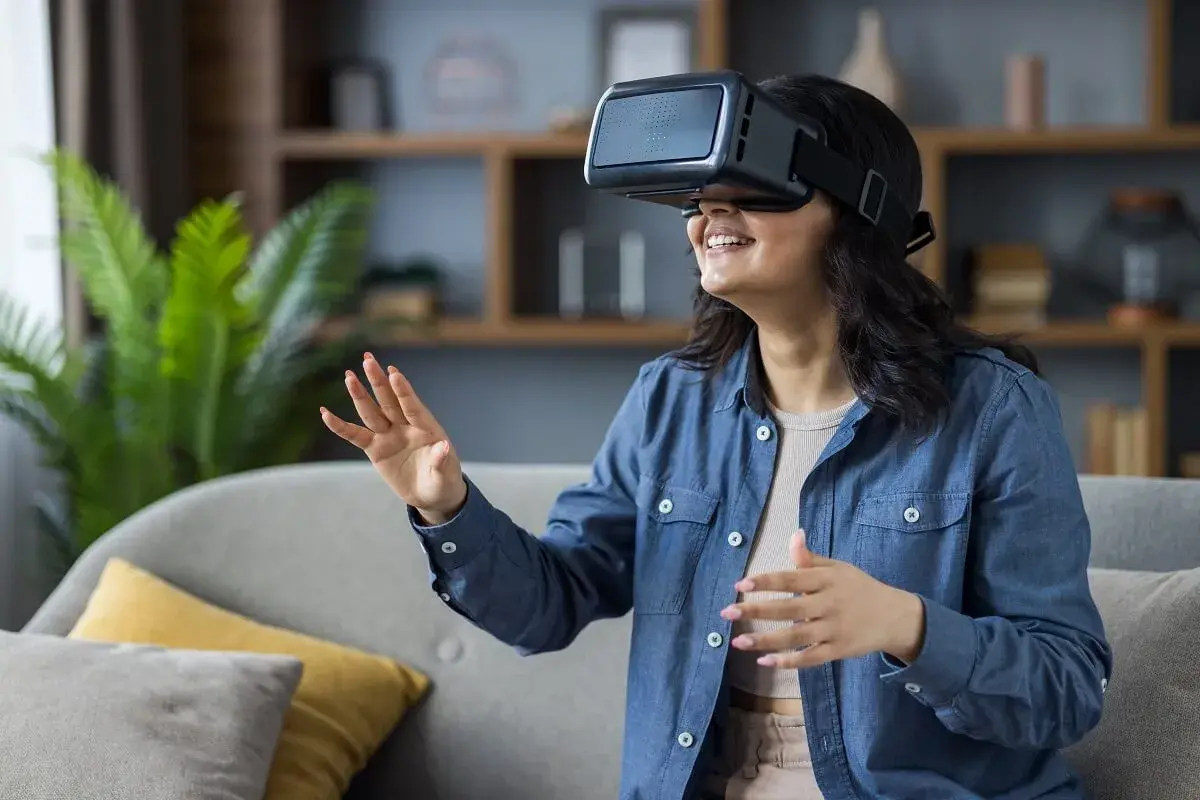 Kobieta w okularach VR, odkrywa jak zbudowane są okulary VR, zanurzając się w wirtualnym świecie.
