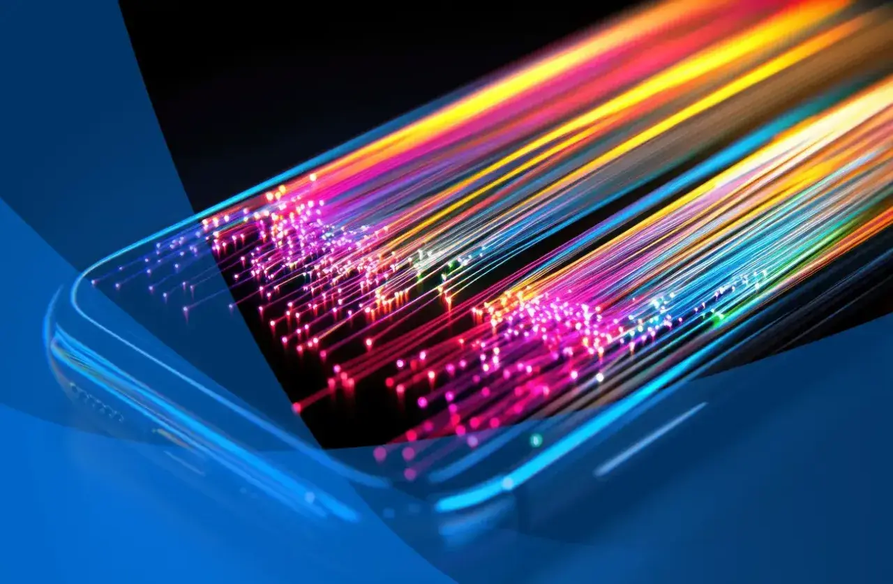 Światłowody w kolorach tęczy wychodzące z telefonu, symbolizujące, co znaczy internet mobilny: szybki i wszechobecny.