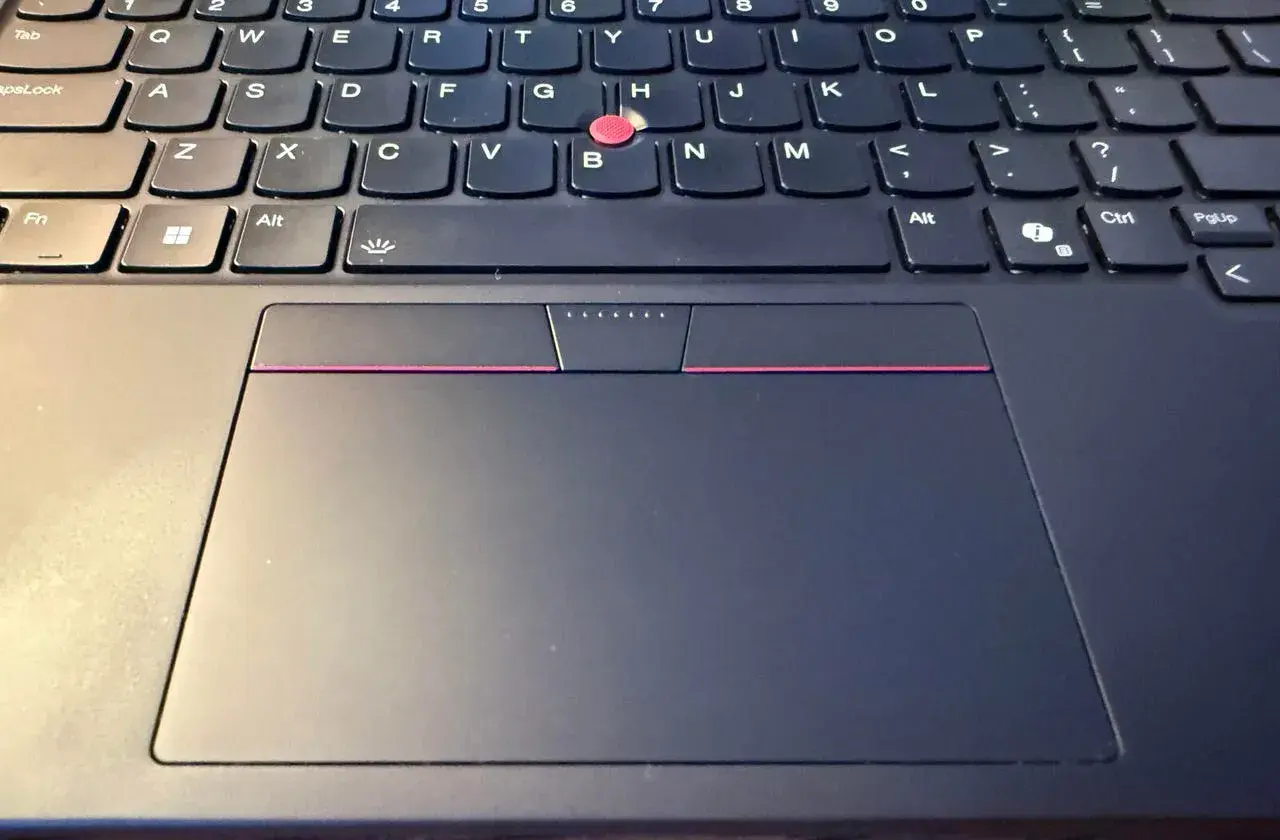 Klawiatura laptopa z touchpadem. Zastanawiasz się, czy da się podłączyć pada do laptopa? Tak, zazwyczaj jest to możliwe przez USB lub Bluetooth.