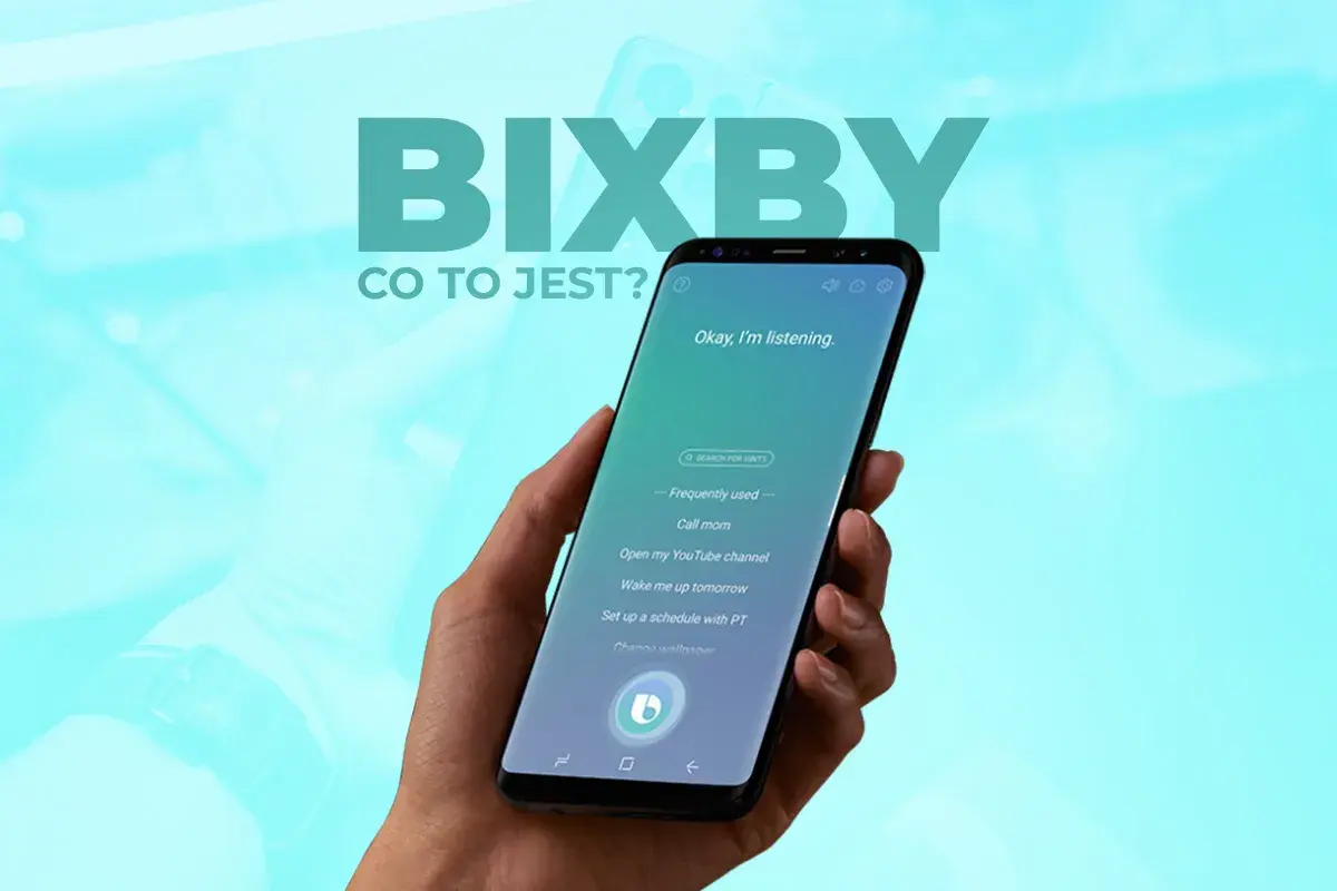 Dłoń trzyma smartfon z włączonym asystentem Bixby. Na ekranie widać komunikat "Okay, I'm listening." oraz przykładowe komendy, np. "Call mom". Bixby co to?