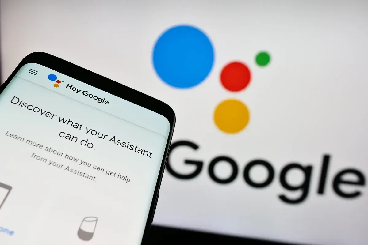 Telefon z ekranem "Hey Google" i logo Asystenta. Dowiedz się, jak wyłączyć Asystenta Google, jeśli potrzebujesz.