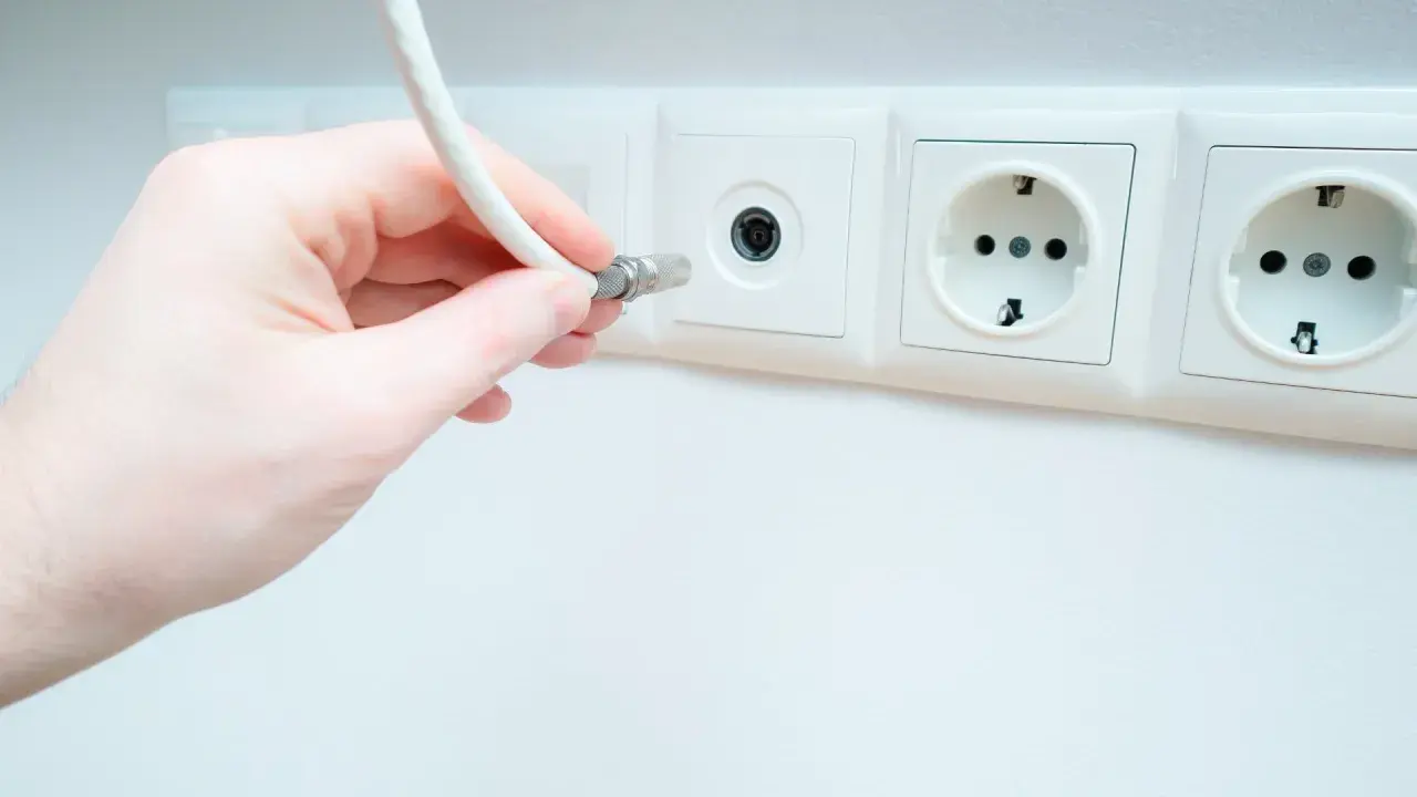 Dłoń podłącza kabel do gniazdka antenowego. Pytanie: jaki kabel do anteny naziemnej?
