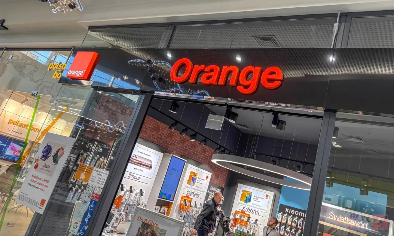 Salon Orange z ofertą "konto ważne rok". W witrynie widać telefony iPhone, Samsung, Xiaomi i ofertę światłowodu.