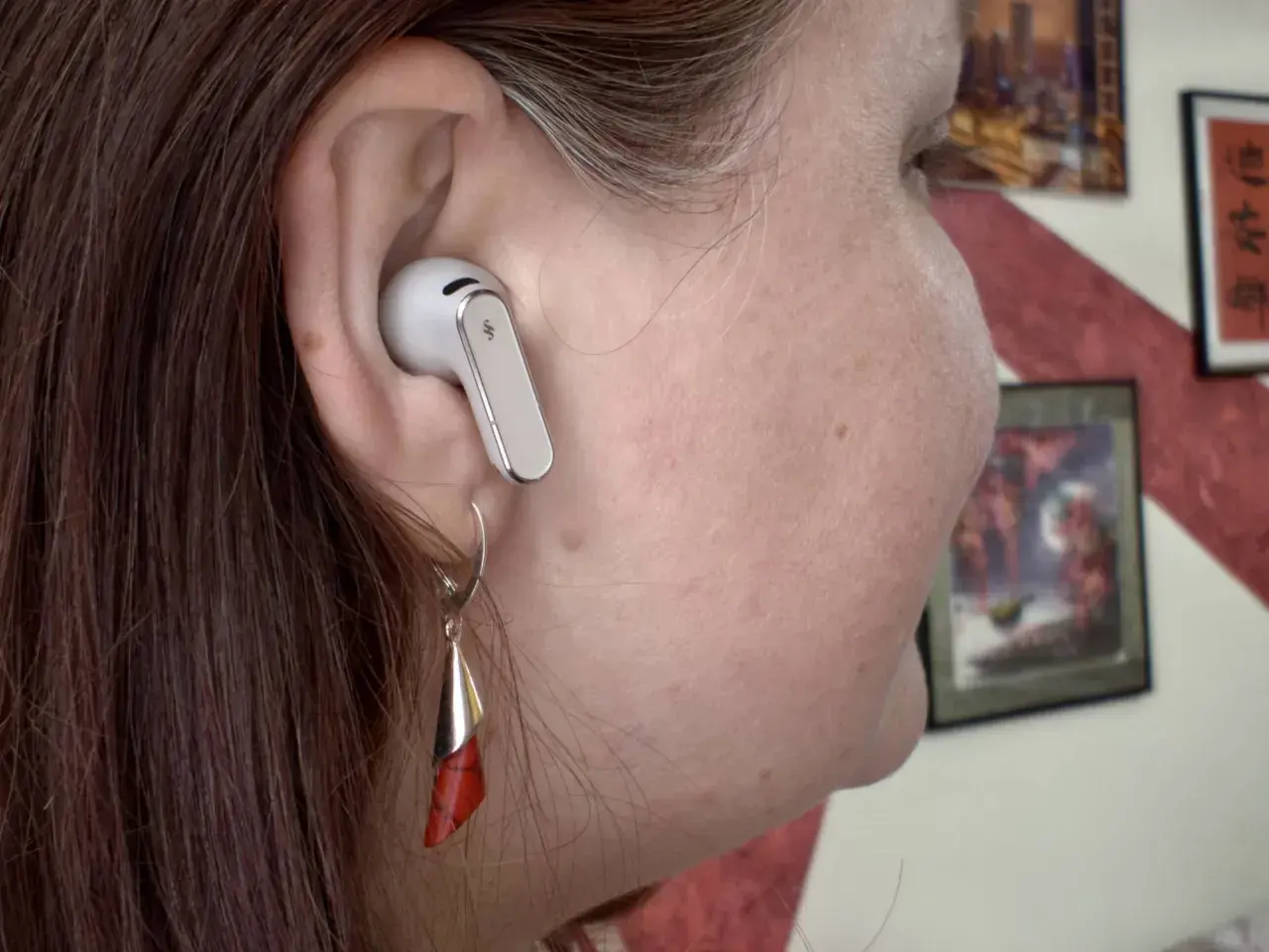 Ucho z białą słuchawką Huawei. Dowiedz się, jak podłączyć słuchawki Huawei do iPhone, by cieszyć się muzyką.