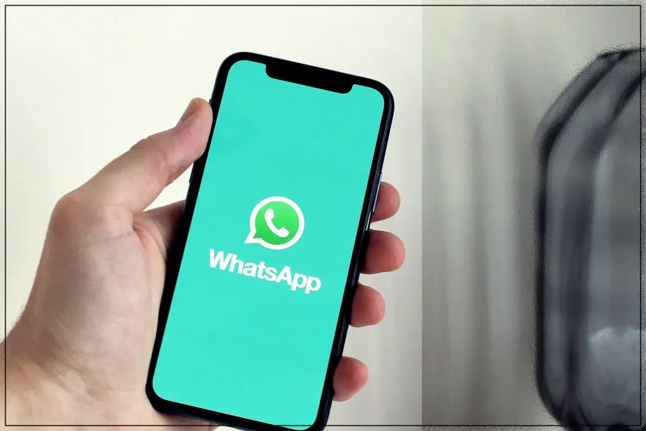 Dłoń trzyma smartfon z logo WhatsApp. Dowiedz się, jak dzwonić bez karty SIM, korzystając z tej popularnej aplikacji.