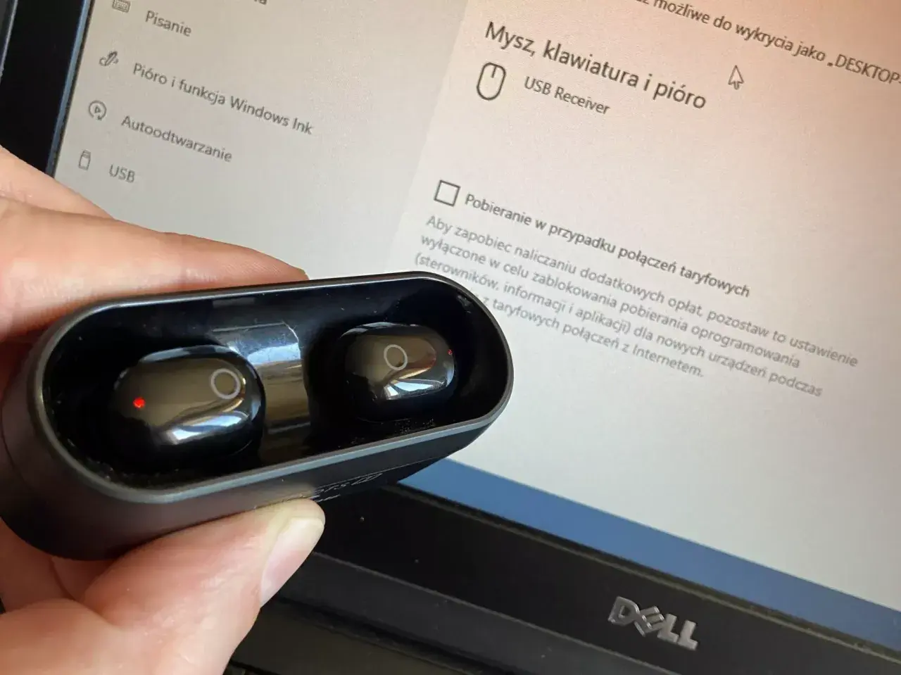 Słuchawki bezprzewodowe w etui, obok ekranu laptopa z ustawieniami USB. Jak podłączyć słuchawki przewodowe do komputera? To proste, wystarczy port.