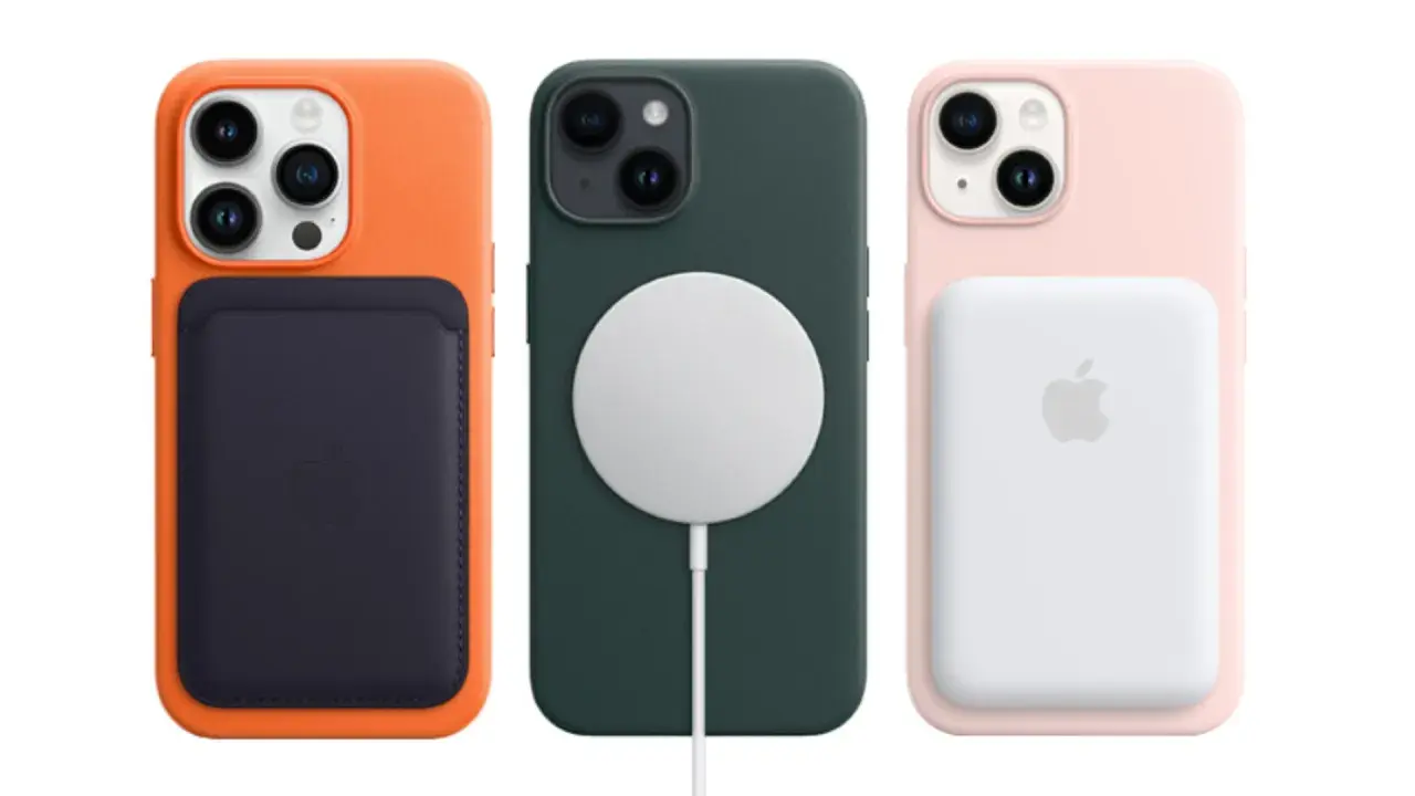 Trzy iPhone'y 14 w kolorowych etui: pomarańczowym z portfelem, zielonym z ładowarką MagSafe i różowym z powerbankiem. Premiera iPhone 14.