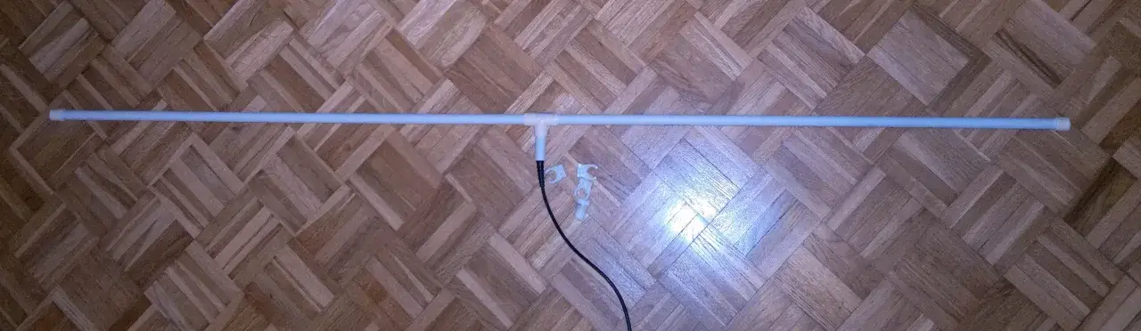 Prosty projekt, jak zrobić antenę radiową FM. Dwie rurki połączone trójnikiem, z czarnym kablem.